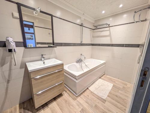 a bathroom with a tub and a sink and a bath tub at Chateau de Quesmy in Quesmy