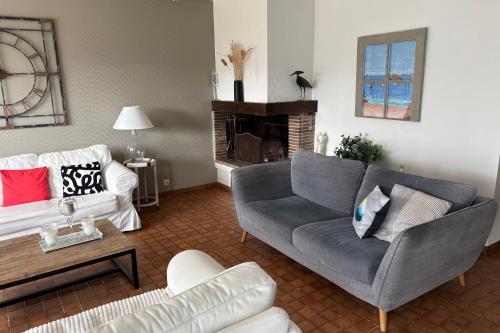 a living room with a couch and a table at Maison les dunes proche plage in Quiberon