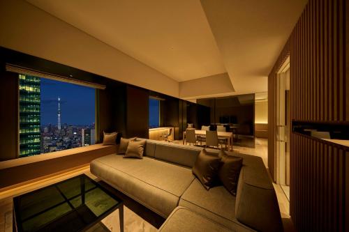 a living room with a couch and a large window at The Royal Park Hotel Iconic Tokyo Shiodome in Tokyo