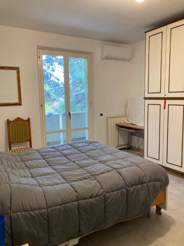 a bedroom with a bed and a table and a window at Meris affittacamere in Monsano
