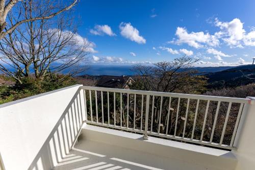 a white balcony with a view of the ocean at AZUR 伊豆熱川 aurora in Higashiizu