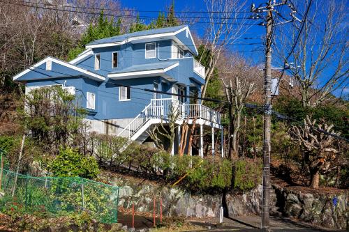 a blue house on the side of a hill at AZUR 伊豆熱川 aurora in Higashiizu
