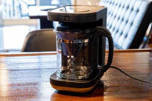a black blender sitting on a wooden table at AZUR 伊豆熱川 aurora in Higashiizu