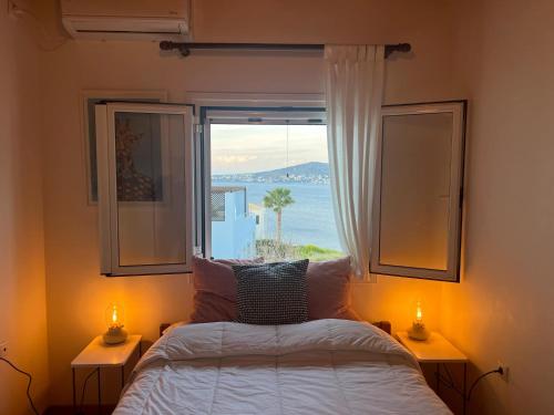 a bedroom with a bed and a window with a view at Perdika's Nest, family friendly house by the sea in Perdika