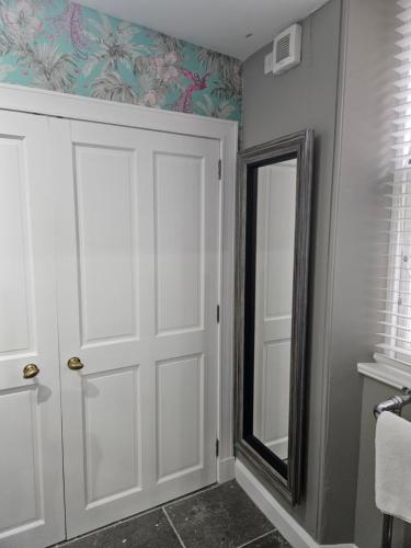 a bathroom with a white door and a mirror at Craggan in Ballater