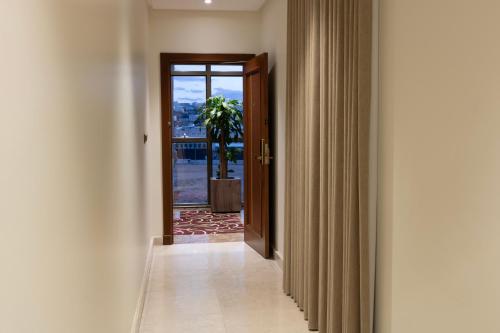 a hallway with a door leading to a room with a window at Bellevue Park Hotel in Taif