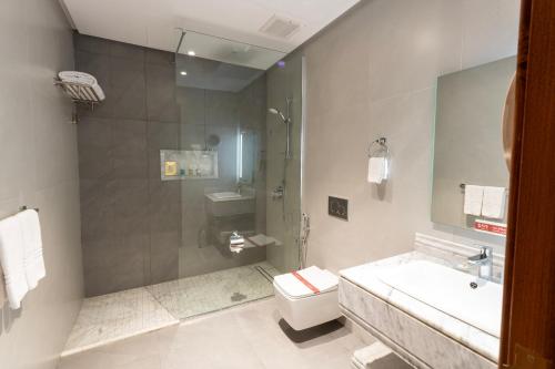 a bathroom with a shower and a toilet and a sink at Bellevue Park Hotel in Taif