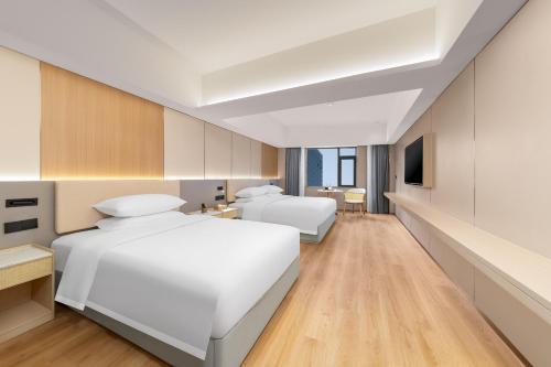 Postel nebo postele na pokoji v ubytování Langju Hotel - Haikou Guomao Center Friendship Sunshine City Branch