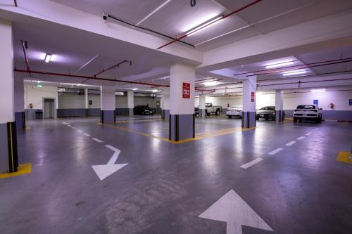 an empty parking garage with white arrows on the floor at Bellevue Park Hotel in Taif