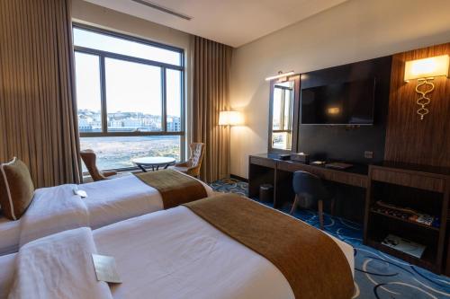 a hotel room with two beds and a flat screen tv at Bellevue Park Hotel in Taif