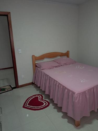 a bedroom with a bed with a pink blanket on the floor at Casa em Vivendas - Pedra Azul in Domingos Martins