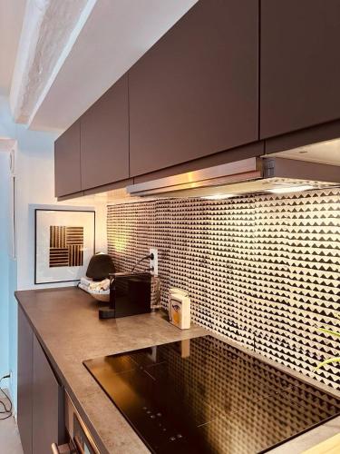 une cuisine avec un comptoir et un mur en carrelage dans l'établissement Centre Historique Coup de Coeur - 5 mins Aéroport, à Blagnac