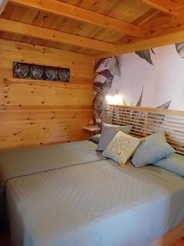 a bedroom with a bed in a wooden room at Cabaña Ikizen II in Barbadillo del Pez