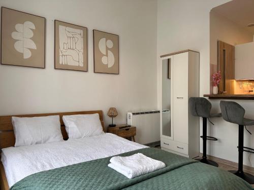 a bedroom with a bed and two chairs at Apartament Pastelowy Kołłątaja in Tomaszów Mazowiecki