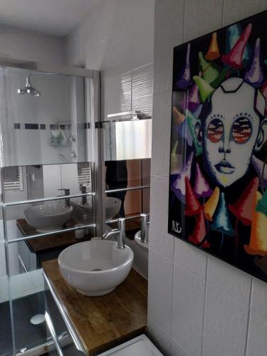 La salle de bains est pourvue de 2 lavabos et d'une peinture murale. dans l'établissement Alizé du lac, à Aix-les-Bains