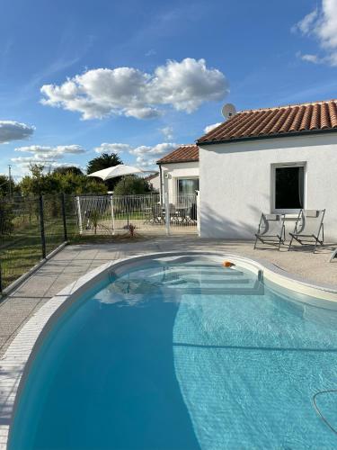 une grande piscine bleue devant une maison dans l'établissement Maison récente avec Piscine à 15' des plages en vélo, à Le Bernard