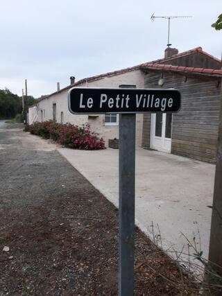 a street sign for le petit village on a pole at Chambre,petit déjeuner inclus in Chantonnay