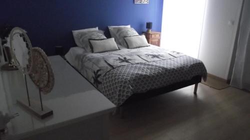 Ce lit se trouve dans une chambre dotée d'un mur bleu. dans l'établissement Chambre,piscine,petit déjeuner inclus, à Chantonnay