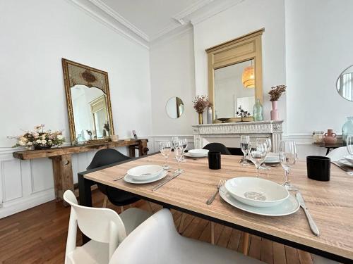 une salle à manger avec une table en bois et des miroirs dans l'établissement Vesle magnifique T4 hyper centre 6 personnes, à Reims