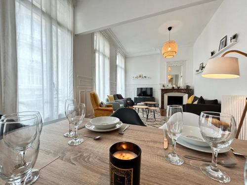 une table à manger avec des verres à vin et un salon dans l'établissement Vesle magnifique T4 hyper centre 6 personnes, à Reims