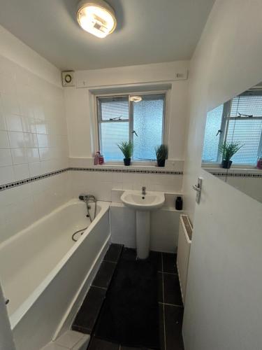 a bathroom with a tub and a sink at Essex Apartment in Loughton