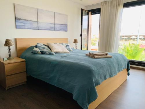 1 dormitorio con 1 cama con manta azul y ventanas en The Atlantica Ocean view apartment, en Dar Bouazza