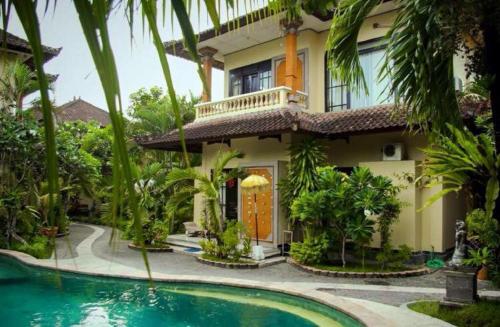 a house with a swimming pool in front of it at Villa Chandra in Seminyak