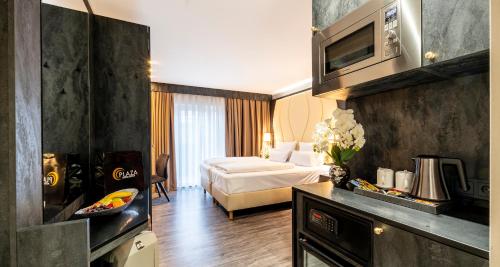 a hotel room with a bed and a living room at PLAZA INN Heilbronn in Heilbronn