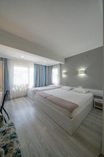 a bedroom with a large white bed in a room at Artunc Hotel Bodrum in Bodrum City