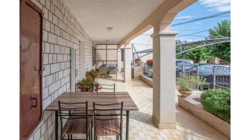 an outdoor patio with a wooden table and chairs at Comfortable apartment in Umag with parking space in Murine