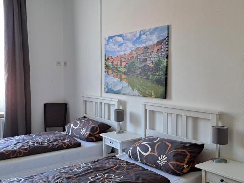 バート・ゾーデン・アレンドルフにあるFerienwohung Villa Cäcilieのベッドが2つあり、壁に絵が飾られた寝室