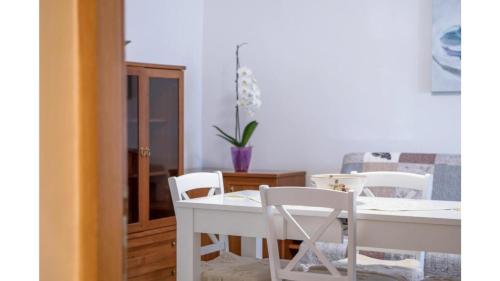 a dining room with a white table and chairs at Comfortable apartment in Umag with parking space in Murine