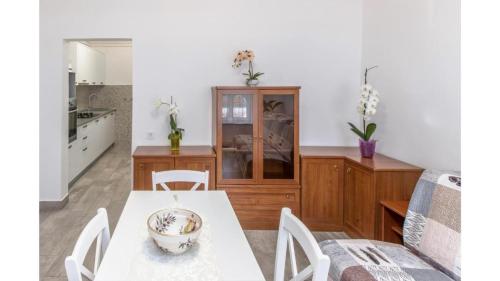 a kitchen and dining room with a table and chairs at Comfortable apartment in Umag with parking space in Murine