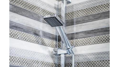 a shower with a shower head on a wall at Comfortable apartment in Umag with parking space in Murine