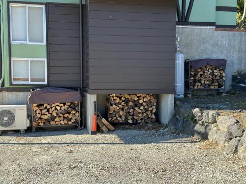 a pile of fire wood under a building at AZUR 伊豆高原 paysage in Futo