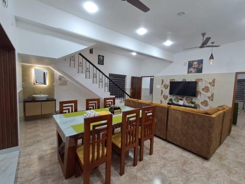 a kitchen and dining room with a table and chairs at Raj Villa in Trivandrum