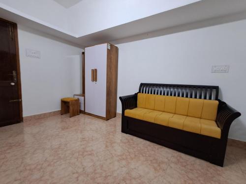 a living room with a yellow couch in a room at Raj Villa in Trivandrum