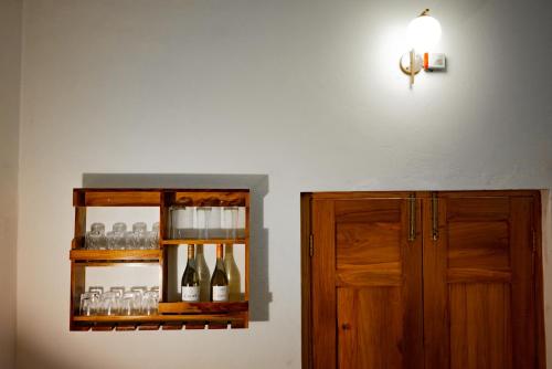 un estante con botellas de vino y un armario en Nook at Adviga by The Staycationer, en Rājpur