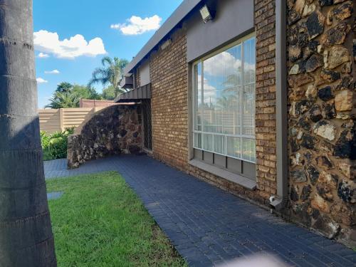 a brick building with a walkway next to a window at TANS Garden Cottage in Centurion