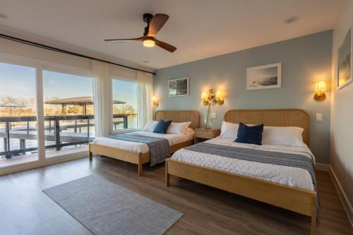 two beds in a bedroom with a balcony at Happy Waves in New Braunfels
