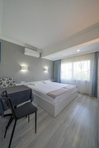 a bedroom with a large bed and a chair at Artunc Hotel Bodrum in Bodrum City