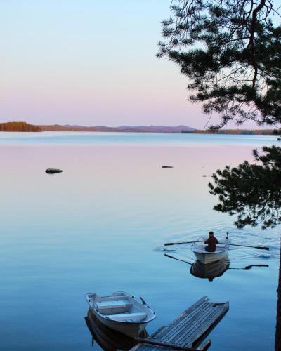 a man is sitting in a boat on a lake at Haven Islands Treehouse on a private island in Torrflonäs