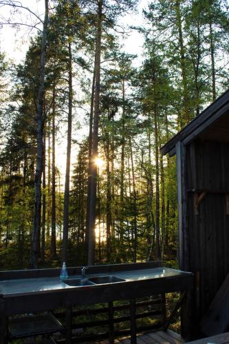 a bath tub with the sun shining through the trees at Haven Islands Treehouse on a private island in Torrflonäs