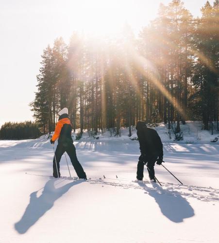 two people are cross country skiing in the snow at Haven Islands Treehouse on a private island in Torrflonäs