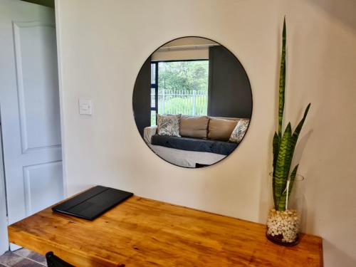 a mirror in a living room with a table and a couch at Riverise Guesthouse in Maun