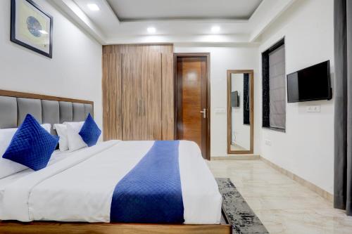 a bedroom with a large bed with blue pillows at Hotel GreySky Near Medanta Hospital in Gurgaon