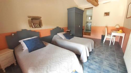 une chambre avec deux lits et une table et des chaises dans l'établissement Mas d'Ambayrac chambres d'hôtes 