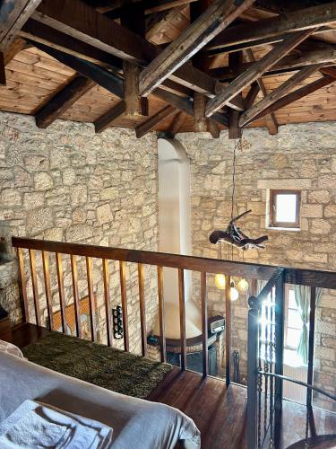 a bedroom with a bed and a stone wall at Saint George Apartments II & III in Kalavrita