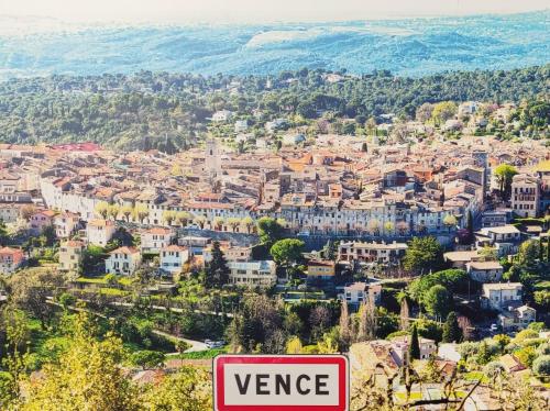 une vue sur une ville avec un panneau au premier plan dans l'établissement T2 clim piscine tout équipé au calme, à Vence
