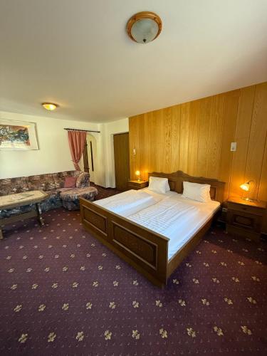 a bedroom with a large bed and a couch at Pension Plattenhof in Telfs